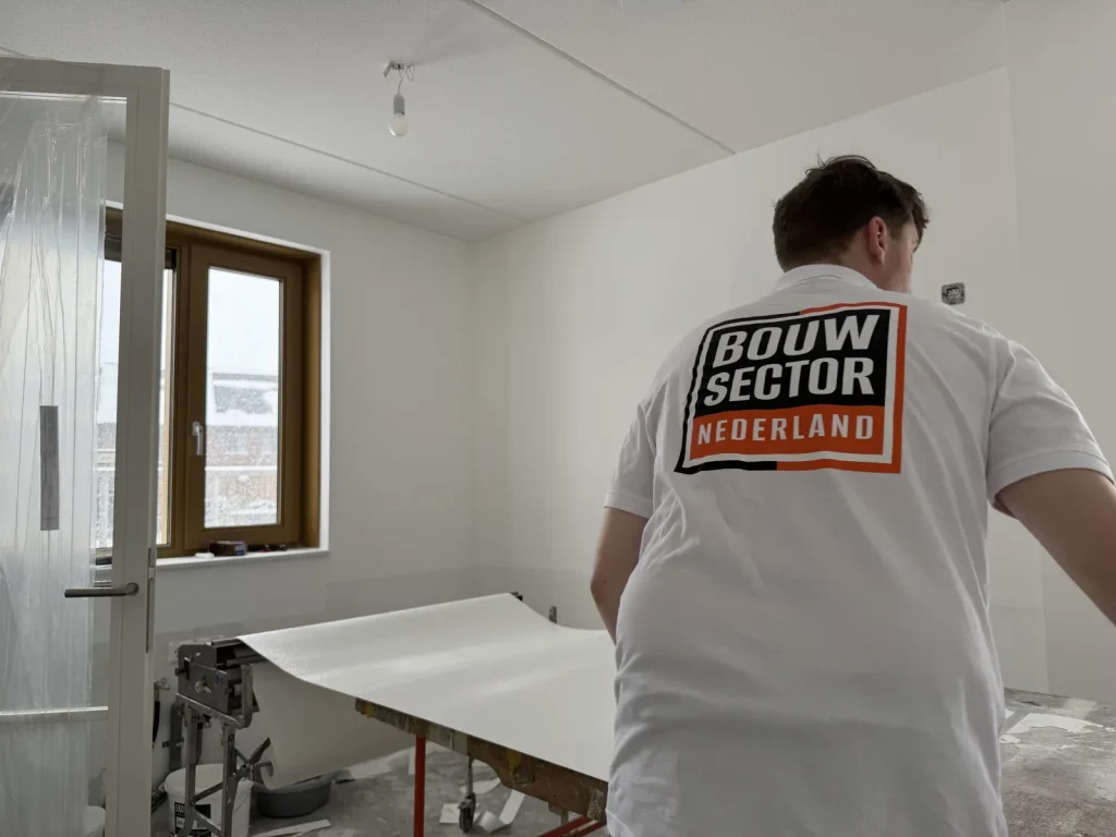 Behanger van Bouwsector Nederland met een baan vlies op de plaktafel